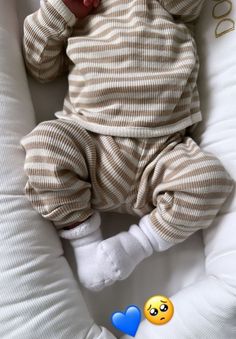 a baby laying on top of a white pillow