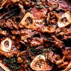 a pan filled with meat and mushrooms covered in sauce