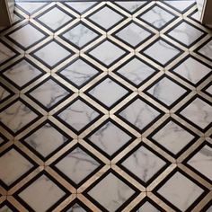 a marble floor with black and white designs on it's sides, next to a window