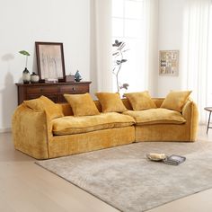 a yellow couch sitting on top of a rug in a living room