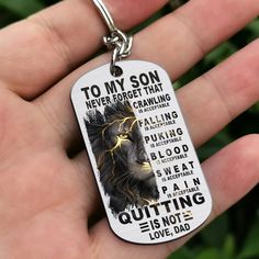 a hand holding a dog tag with the words to my son