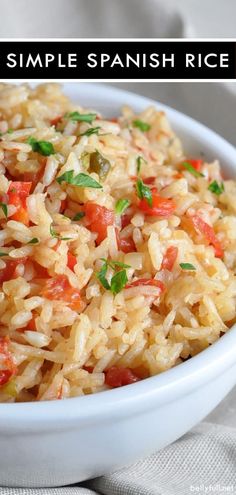 a close up of a bowl of rice with tomatoes and parsley on the side