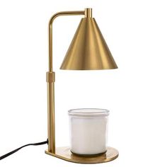 a table lamp with a white container on the base and a gold colored metal shade