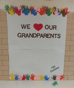 a sign that says we love our grandparents with handprints on it and the words, we love our grandparents