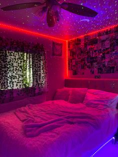 a bedroom with purple lights and pictures on the wall above the bed is lit up