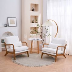 a living room with two chairs and a table in front of a window on the floor