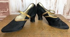 These beautiful shoes were made from black satin in the  late 1920s / early 1930s. They were fashioned in the classic elongated shape of the period with super flattering heel height. The edges of the shoe have been bound in gold coloured leather and there is a securing strap that rubs across the foot and fastens with a small button. Inside, the sole and fabric are lined in cream leather and labelled size 4 inside and in the outer sole.    Size: UK 4 - The shoes are very narrow, please enquire for exact measurements if required.   The shoes are in very good condition with only a few faint scuffs and wear to the heels and soles as pictured.   4499 Fitted Pointed Toe Evening Dance Shoes, Fitted Pointed Toe Dance Shoes For Evening, Vintage Fitted Dance Shoes With Low Heel, Vintage Fitted Closed Toe Dance Shoes, Fitted Vintage Dance Shoes With Low Heel, Vintage Formal Dance Shoes With Almond Toe, Vintage Fitted Dance Shoes For Evening, Vintage Almond Toe Dance Shoes For Formal Events, Vintage Almond Toe Dance Shoes For Formal Occasions