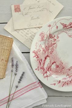 a plate with some flowers on it next to two napkins and a piece of cork