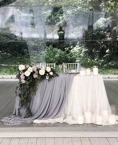 the table is set up with candles and flowers on it for an elegant wedding reception