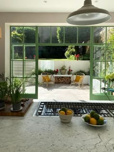 a kitchen with an oven, sink and green glass doors leading to the outside patio