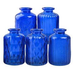 six blue glass vases are lined up together