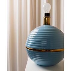 a blue vase sitting on top of a white table