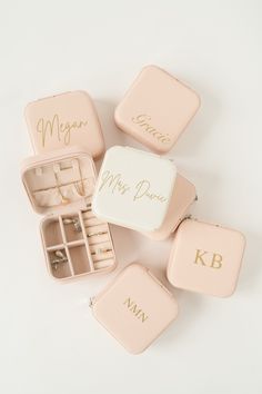 four pink jewelry boxes with personalized rings and ring cases in them on a white surface