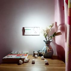 a vase filled with flowers sitting on top of a wooden table next to a window