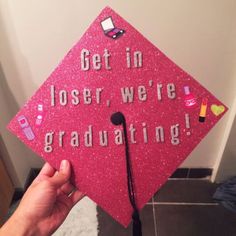 a pink graduation cap that says get in closer, we're graduating