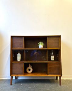 a wooden shelf with vases and bottles on it