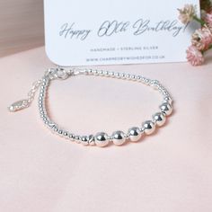 "Sterling silver bead bracelet for a 60th birthday. This lovely handmade bracelet is designed to celebrate a 60th birthday with 6 large shiny beads representing 6 decades. Made from all solid sterling silver, it's a really lovely way to mark this special birthday. Sterling bead bracelets look gorgeous worn singly or as part of a stack - either way the classic look of shiny silver is easy to wear and goes with anything. The bracelet has an extender chain making it adjustable between 6.75\" and 8\" and suitable for most wrist sizes. You can add one of our lovely mini sterling silver birthstone charms to make it even more personal. It comes beautifully presented with a 'SIXTY' backing card in one of our foil printed gift boxes with ribbon tie. Components: * Sterling silver beads - 3mm to 6mm Happy 60th Birthday, Chain Making, Sterling Silver Bead Bracelet, Birthday Bracelet, Silver Bead Bracelet, Backing Card, Bracelet Sterling Silver, Bead Bracelets, Silver Bead