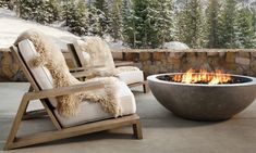 an outdoor fire pit with two chairs around it