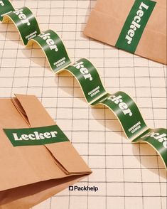 several pieces of brown paper with green lettering on them and tape running down the center of each piece