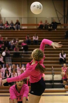 two girls are playing volleyball on the court