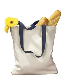 a tote bag filled with bread and a yellow flower on the side, sitting in front of a white background