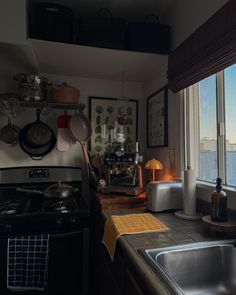 a kitchen with a sink, stove and window overlooking the city below in front of it