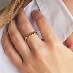 a close up of a person wearing a gold ring