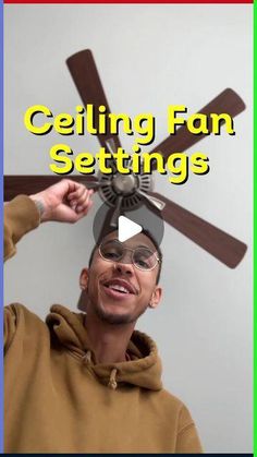 a man in a brown hoodie is holding a ceiling fan with the words ceiling fan settings above his head