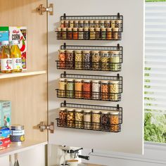 a wall mounted spice rack with spices and condiments on it in a kitchen