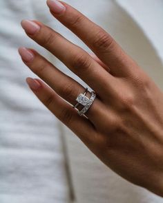 a woman's hand with two rings on it