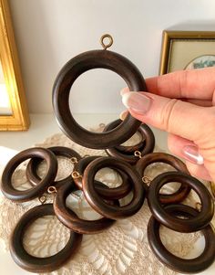 a woman holding onto some wooden rings on top of a table