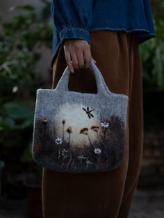 a person holding a bag with flowers on it