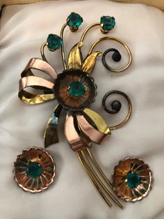 Wonderful UNUSED floral brooch and matching screw back earring set by HARRY ISKIN in original box. The set was made in the late 40s/early 50s and in wonderful condition. Made of 1/20 12K in yellow and rose gold filled, the flowers are set with faux emerald stones. The set, as mentioned, was never worn and only taken out of the box for picture taking. Has some tarnish from age but will polish up great! I polished the two gold balls at the end of the scrolls for the first pic. They were blackened Retro Screw Back Jewelry Gift, Vintage Brooches With Matching Earrings For Gift, Mid-century Flower Jewelry Gift, Vintage Hallmarked 14k Gold Brooches, Antique Gold Flower Brooches, Vintage Yellow Gold Flower Brooches, Vintage Collectible Screw Back Brooches, Victorian Gold Brooch With Screw Back, Emerald Stone