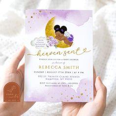 a person holding up a purple and gold baby shower card with the words heaven sent on it