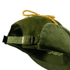 a green hat with yellow straps on it