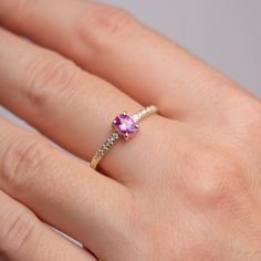 An engagement ring made of 14K solid gold with a natural vivid pink Ceylon sapphire unheated and untreated oval cut on top, with side diamonds on the band. It has a comfort fit, so you can wear it everyday.  100% handcrafted. D E T A I L S ● Metal: 14K solid gold ● Gemstone: Pink Sapphire, unheated and untreated oval cut, Diamonds  ● Gemstone's weight: Sapphire 1.02 ct, Diamonds 0.08 ct, color G, clarity SI H O W ∙ T O ∙ O R D E R Choose from the drop-down menus of the available options (Ring size) and leave us a note for any special requirements. G I F T S All our pieces are delivered beautifully packaged and gift ready. P R O D U C T I O N ∙ T I M E * S H I P P I N G  Please keep in mind that each item is handcrafted, and we need 5 days at least for its production. If you need your order Luxury Pink Oval Sapphire Ring, Oval Ruby Ring With Brilliant Cut Pink Sapphire, Formal Oval Pink Sapphire Ring, Pink Sapphire Ring With Rose Cut Diamonds As Gift, Gift Pink Sapphire Ring With Rose Cut Diamonds, Classic Pink Oval Ruby Ring, Classic Pink Sapphire Ring With Accent Stones, Classic Pink Sapphire Ring With Rose Cut Diamonds, Pink Oval Ruby Ring With Center Stone