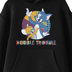 Celebrate your favorite cartoon characters with this Tom & Jerry sweatshirt. The hoodie features an image of Tom and Jerry in a colorful circle while multicolored letters below the characters read, "Double Trouble." The sweatshirt comes in black with a double-lined hood and a large pouch pocket. Fans of the Tom & Jerry cartoons will love this comfy sweatshirt. Cartoon Style Cotton Top With Letter Print, Cotton Cartoon Style Tops With Letter Print, Multicolor Cartoon Print Hooded Hoodie, Pop Culture Hooded Sweatshirt With Character Print, Casual Cartoon Print Hoodie For Fans, Character Print Hoodie Sweatshirt For Fans, Character Print Fan Merchandise Hoodie, Pop Culture Graphic Print Hoodie, Pop Culture Long Sleeve Hoodie With Letter Print