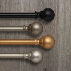 three different types of door knobs on a wooden surface with black and gold handles