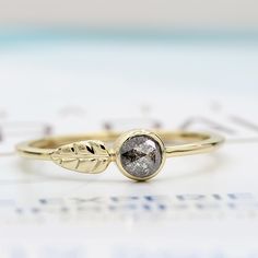 a close up of a ring with a leaf design on the front and back side