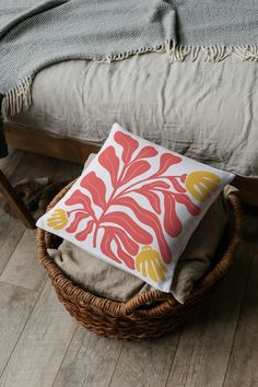 a pillow sitting on top of a basket next to a bed