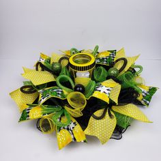 a yellow and black wreath with green ribbons