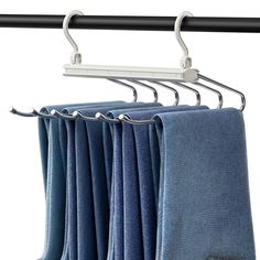 three blue towels hanging on a metal rod with clothes hangers in front of them