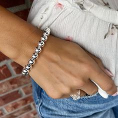 Every girl needs the classics... Our Classic Bead Bracelet comes to you in sterling silver with a magnetic closure and added secure safety chain. The generously sized beads measure approximately 9mm in diameter and create a look that is bold enough to wear alone or, if silver shine in layers is your style, can be stacked up with your favorites. The easy hidden closure contains a magnet that makes it a breeze to slip on or off. Available in 2 sizes:Standard (7.5 inches)Large (8.0 inches) for a sm Classic Adjustable Stretch Bracelet With Silver Beads, Classic Silver Beads Stretch Bracelet For Everyday, Classic Silver Round Beads Stretch Bracelet, Classic Adjustable Sterling Silver Stretch Bracelet, Classic Adjustable Sterling Silver Bracelet With Spacer Beads, Classic Silver Beaded Bracelets With Sterling Silver Clasp, Classic Silver Bracelets With 8mm Beads, Classic Sterling Silver Bracelet With Spacer Beads, Classic Sterling Silver Bracelet With Polished Beads