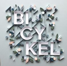 the words bicycly kell are cut out of paper and placed on top of each other