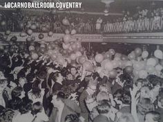 an old black and white photo of people at a party with balloons in the air