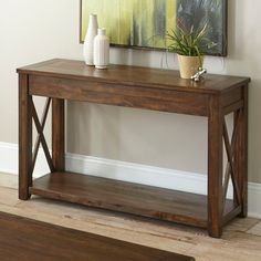 a wooden table with two vases on top of it and a mirror above it