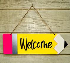 a welcome sign hanging on a wooden wall