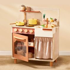 a wooden toy kitchen with an oven, sink and stove top on carpeted floor