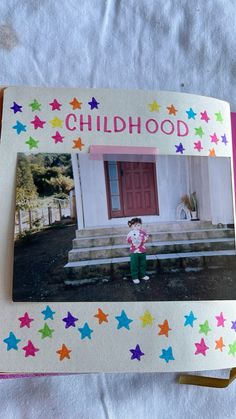 an open book with a child's picture on the cover and stars around it