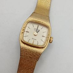 This vintage Citizen Seven ladies wristwatch is a timeless piece that will complement any outfit. With a square watch shape and a two-piece gold strap, it exudes elegance and sophistication. The watch features an analog display and is powered by a quartz movement, ensuring accurate timekeeping. The gold bezel and case material add to its charm, while the reference number 4-833554 confirms its authenticity. Made in Japan, this watch is a rare find for collectors and fashion enthusiasts alike. Perfect for women who appreciate classic designs, it is a valuable addition to any watch collection. Gold Square Watch For Formal Occasions, Classic Gold Square Watch Accessories, Vintage Gold Square Watch, Timeless Gold Square Watch, Gold Square Analog Watch, Gold Square Analog Watches, Gold Square Watch With Metal Dial, Bracelet Vintage, Square Watch